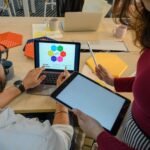 Creative meeting with digital devices in a modern office, showcasing teamwork and collaboration.